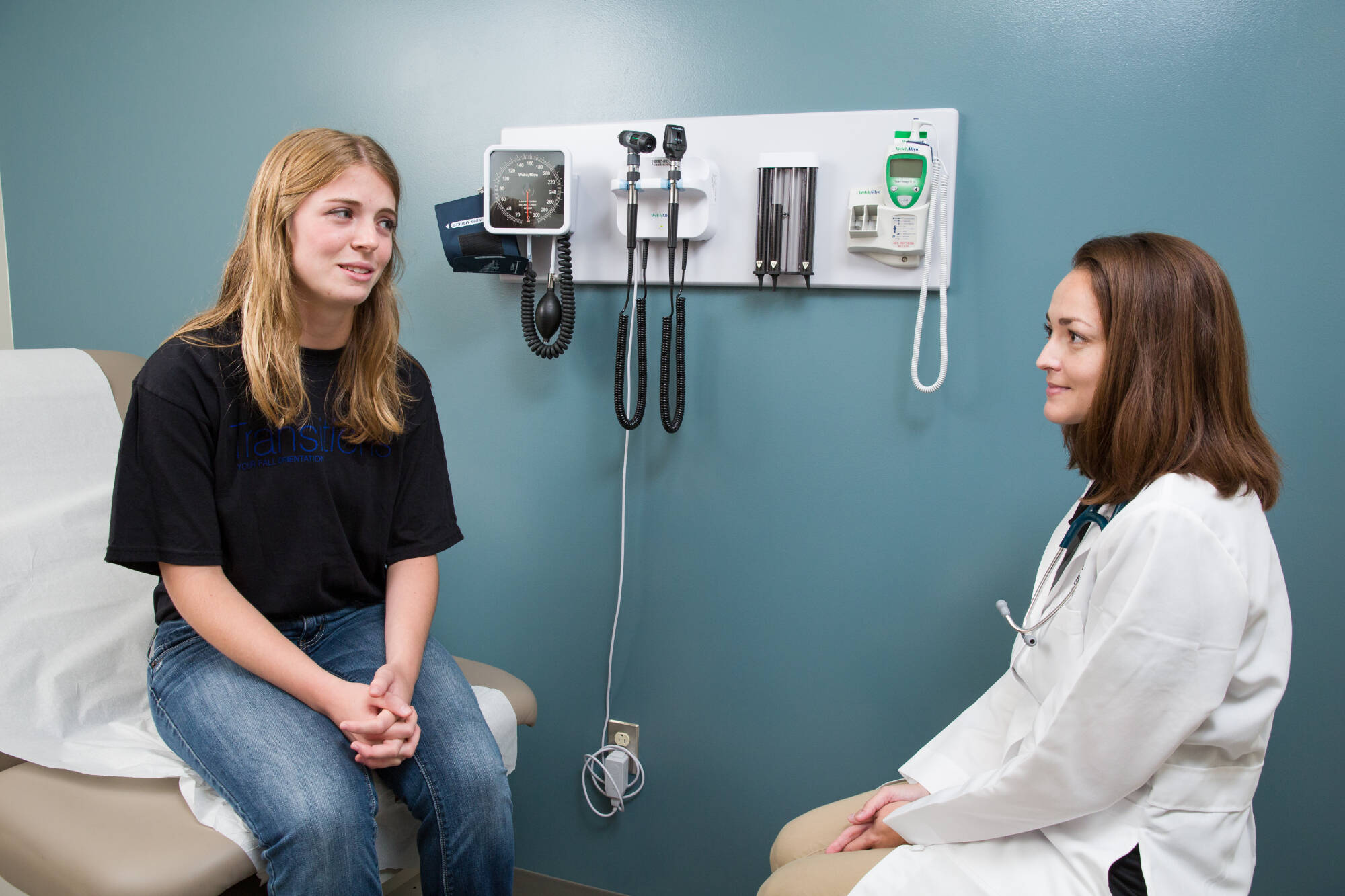 A patient in an examination room speaking with a health care provider.